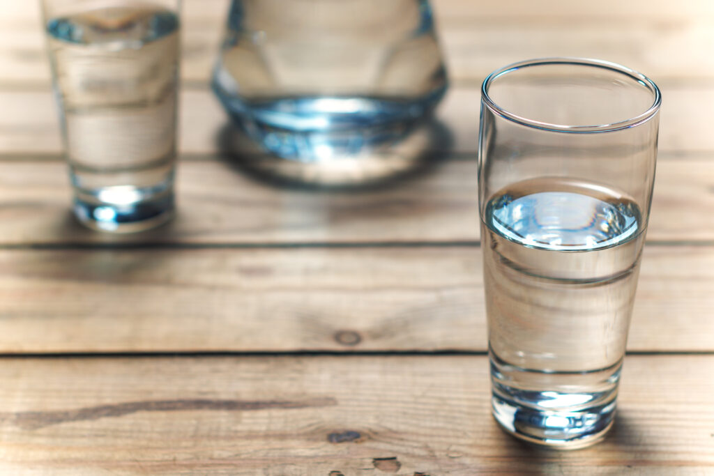 Glasses of water on a wooden table.