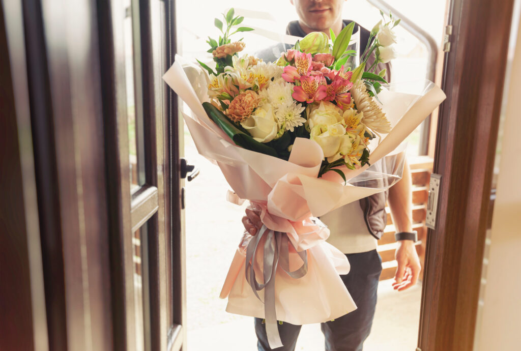 Man delivers a bouquet of flowers.