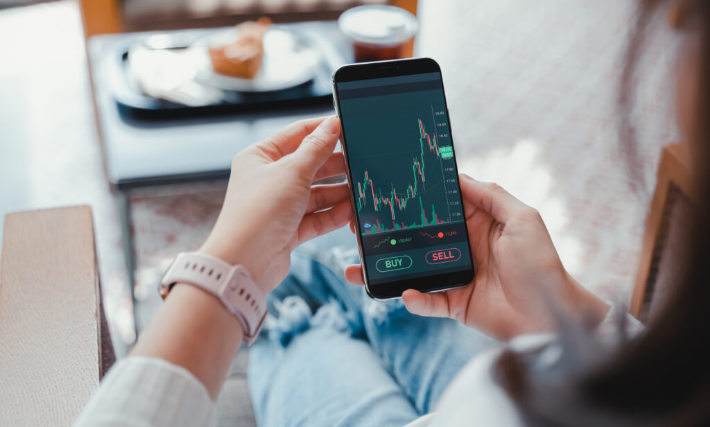 Woman using smart phone to check investment portfolio.